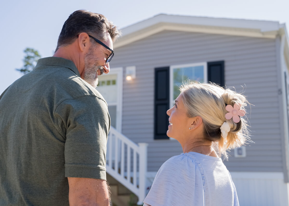Residents standing outside near a manufactured home